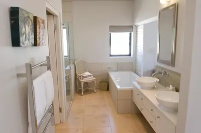 a bathroom with a tub and a sink and a mirror at 14 On Louw in Stellenbosch