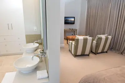 a bathroom with a sink and two chairs in a room at 14 On Louw in Stellenbosch