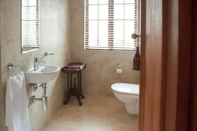 a bathroom with a sink and a toilet at Blaauwheim Guest House in Somerset West