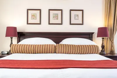 a bedroom with a bed with two pillows and two lamps at Blaauwheim Guest House in Somerset West