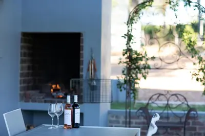 a table with two bottles of wine and two glasses at Sweetwater Guesthouse in Wellington