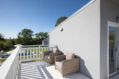 a deck with chairs on a house at Sweetwater Guesthouse in Wellington