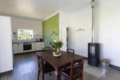 a kitchen with a table with chairs and a stove at Sweetwater Guesthouse in Wellington