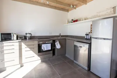 a kitchen with stainless steel appliances and white cabinets at Sweetwater Guesthouse in Wellington