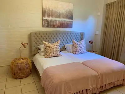 a bedroom with a large bed with pillows at Groenvlei Guest Farm in Kuilsrivier