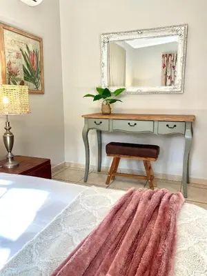 a bedroom with a dressing table with a mirror at Groenvlei Guest Farm in Kuilsrivier