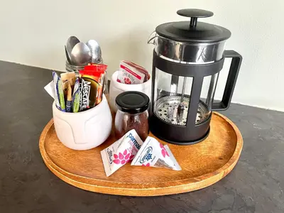 a coffee maker sitting on a wooden tray with spices at Groenvlei Guest Farm in Kuilsrivier