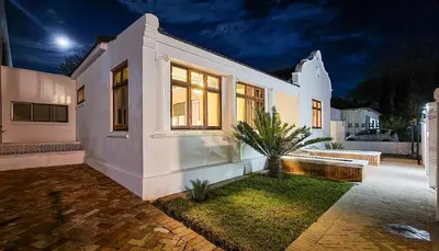 a white house with a bench in the yard at Batavia Boutique Hotel in Stellenbosch