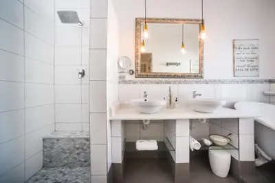 a bathroom with two sinks and a mirror at Batavia Boutique Hotel in Stellenbosch