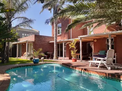 a swimming pool in front of a house at Elements Cape Town in Table View
