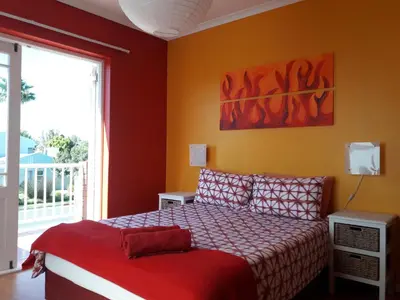 a bedroom with a bed and a large window at Elements Cape Town in Table View