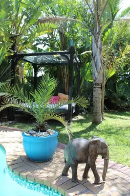 a statue of an elephant walking next to a pool at Elements Cape Town in Table View