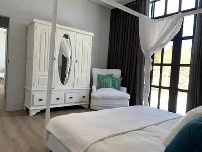 a bedroom with a bed and a dresser and a mirror at Anna Beulah Farm in Durbanville