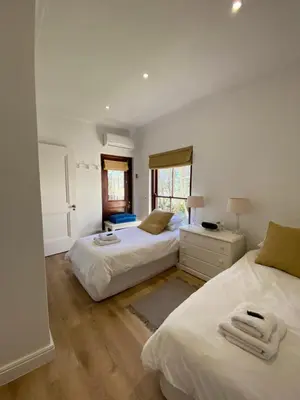 a bedroom with two beds and a window at @Leisure Guest Suite in Stellenbosch