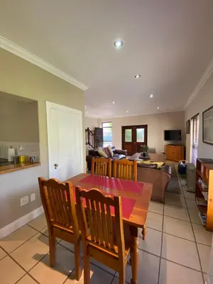 a kitchen and living room with a wooden table and chairs at @Leisure Guest Suite in Stellenbosch