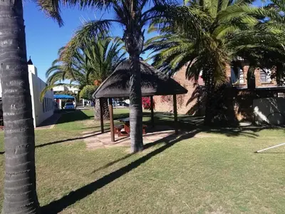 a gazebo in a park with palm trees at Amies Self-Catering Apartments in Panorama