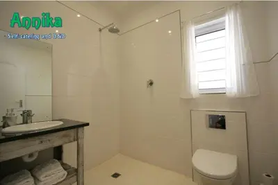 a white bathroom with a toilet and a sink at Annika Self-catering and B&B in Stellenbosch