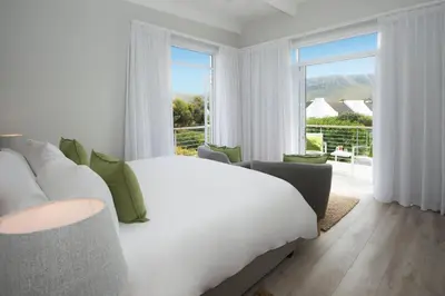 a bedroom with a large bed and a large window at Bamboo Guest House in Hermanus