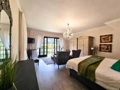 a bedroom with a bed and a living room at Mulligans Guest Lodge in Hermanus