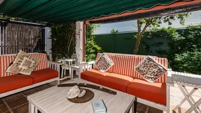 a patio with two couches and a table at Brown Jug Guest House in Hermanus