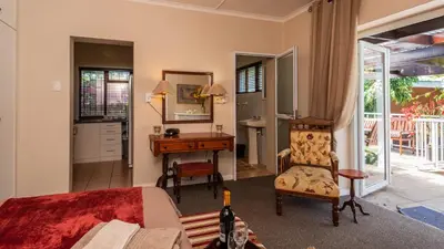 a bedroom with a bed and a desk and a chair at Brown Jug Guest House in Hermanus