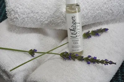 a bottle of soap and flowers on a towel at OnQ Accommodation in Bellville