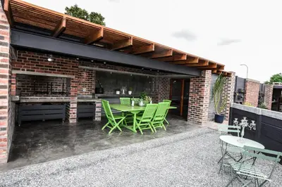 a patio with a table and chairs and a brick building at OnQ Accommodation in Bellville