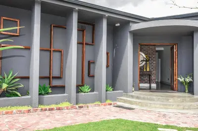 a facade of a house with a door and some plants at OnQ Accommodation in Bellville