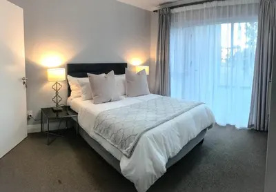 a bedroom with a large bed and a large window at 131 Yellowwood Ashton Park in Cape Town