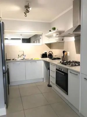 a white kitchen with a sink and a stove at 131 Yellowwood Ashton Park in Cape Town