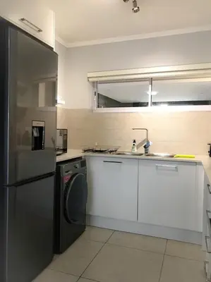 a kitchen with a refrigerator and a sink and a dishwasher at 131 Yellowwood Ashton Park in Cape Town