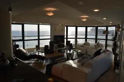 a living room with white furniture and large windows at Ocean View 201A in Strand