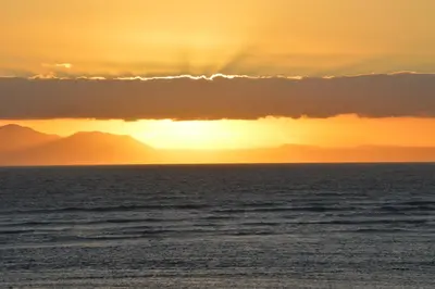 a sunset over the ocean with a rainbow at Ocean View 201A in Strand