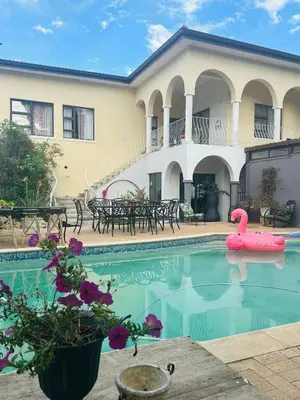 a pool with a pink swan in front of a house at Welgemoed Villa in Bellville