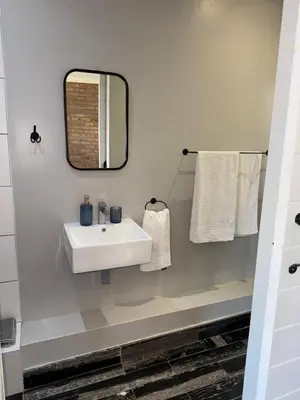 a bathroom with a sink and a mirror and towels at Welgemoed Villa in Bellville