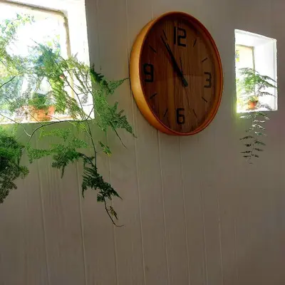 a clock hanging on a wall next to a window at The Wild Fig in Durbanville