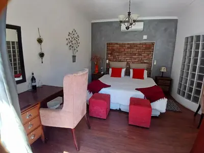 a bedroom with a bed and a desk and a chair at Ons Stee Bed and Breakfast in Wellington