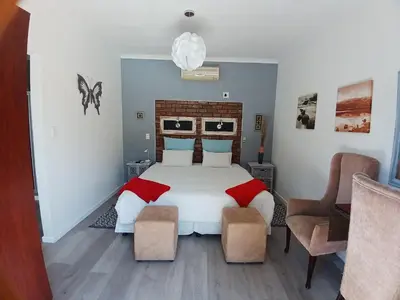 a bedroom with a large white bed with red pillows at Ons Stee Bed and Breakfast in Wellington