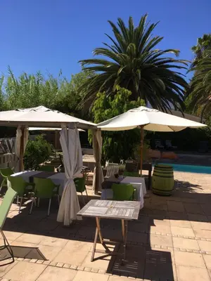 a patio with tables and umbrellas next to a pool at Ons Stee Bed and Breakfast in Wellington