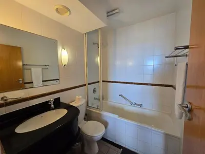 a bathroom with a sink and a toilet and a tub at False Bay Inn in Strand