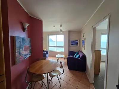 a living room with a table and a couch at False Bay Inn in Strand