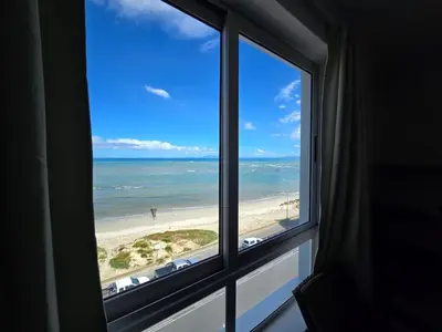 a view of a beach from a window at False Bay Inn in Strand