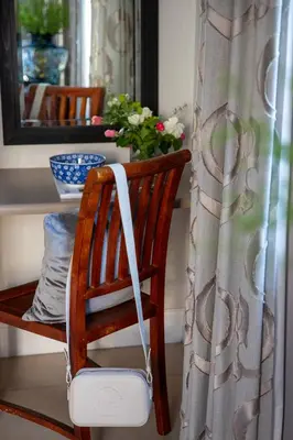 a wooden chair in a room with a window at Lemoenkloof Boutique Hotel in Paarl