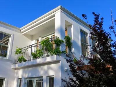 a white house with plants on the balcony at Penelope's Stellenbosch in Stellenbosch