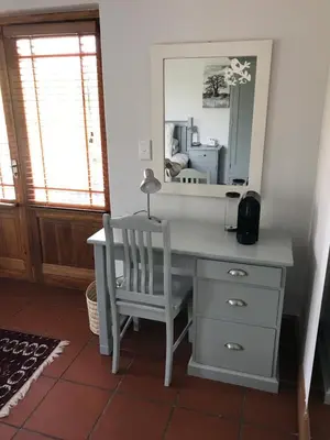 a desk with a chair and a mirror at Penelope's Stellenbosch in Stellenbosch