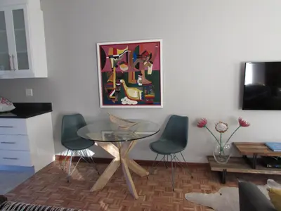 a living room with a glass table and two chairs at Live Like a Local: Studio 29 @ 25 Market street in Stellenbosch