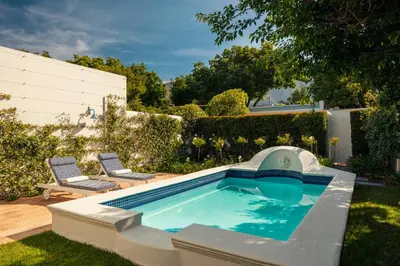 a swimming pool with a slide in a yard at Le Quartier Francais in Franschhoek