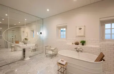 a white bathroom with a tub and a sink at Babylonstoren in Simondium