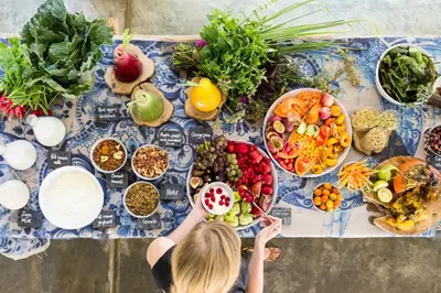 a woman standing at a table with a bunch of food at Babylonstoren in Simondium
