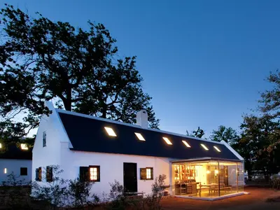 a large white building with a black roof at Babylonstoren in Simondium
